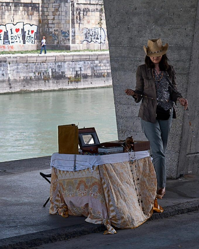 Eine Frau mit Flohmarkttisch unter seiner Brücke