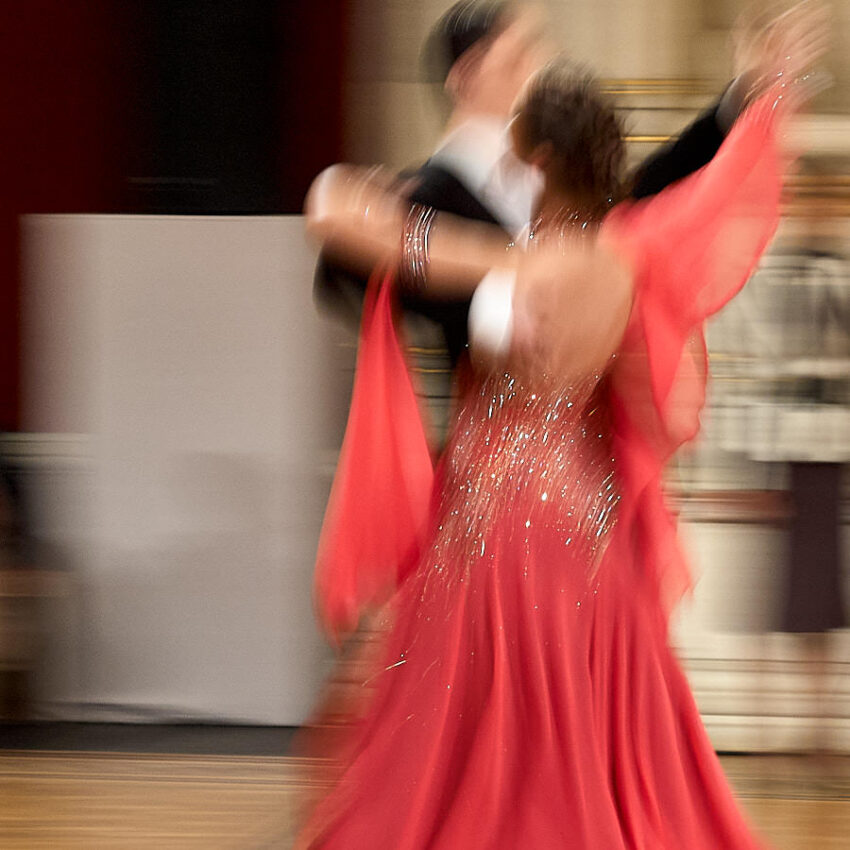 Ein Mann und eine Frau tanzen, die Frau in einem roten Kleid