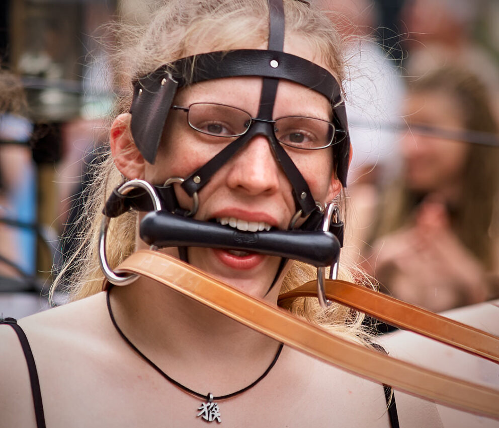 Frau mit Brille, Zaumzeug und Gebissstange