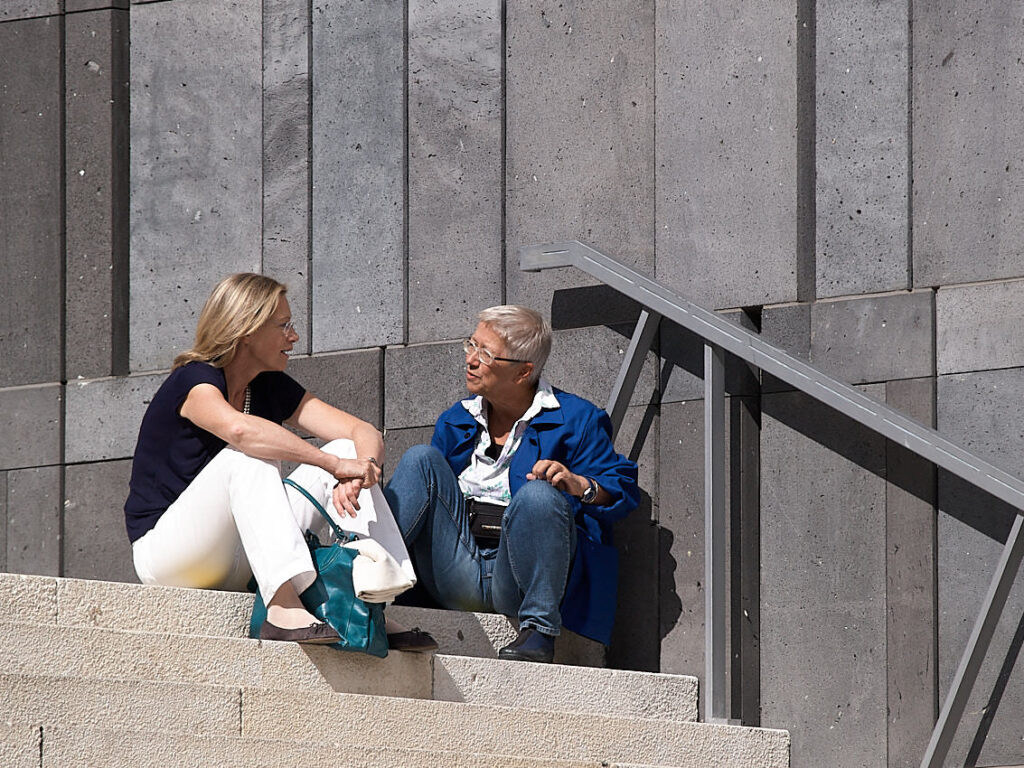Zwei Frauen, auf einer Treppe sitzend