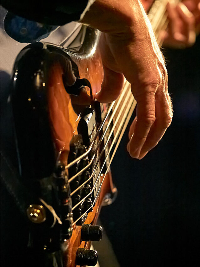 Eine Hand, die Gitarrensaiten schlägt