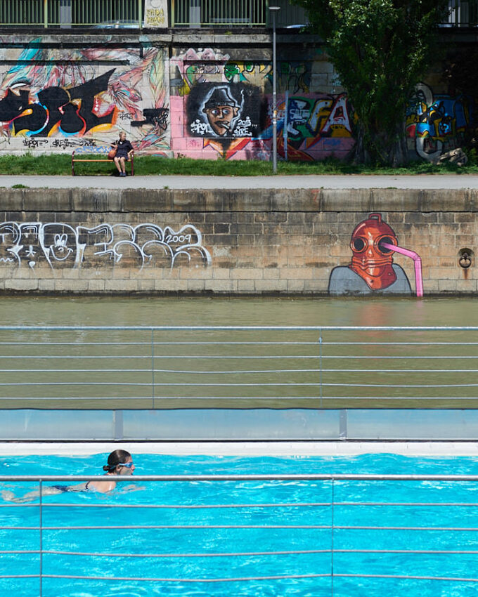 Eine Schwimmerin vor einer Wand mit Graffiti