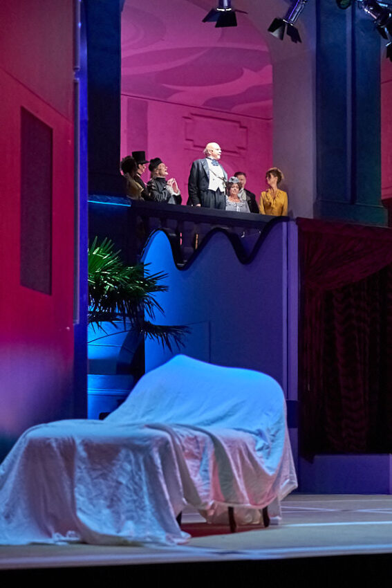 Einige Schauspieler auf einem Balkon über der Bühne