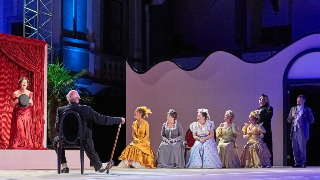 Eine Schauspielerin auf der Bühne vor einem Mann und einigen Damen