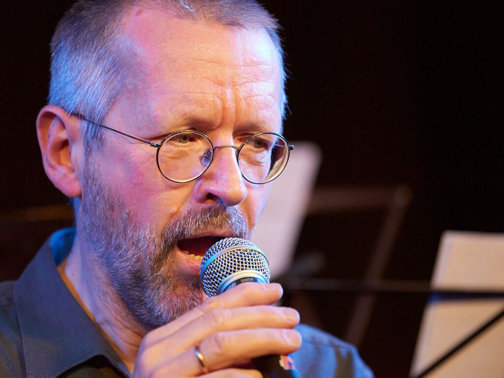 Ein Mann singt in ein Mikrofon.