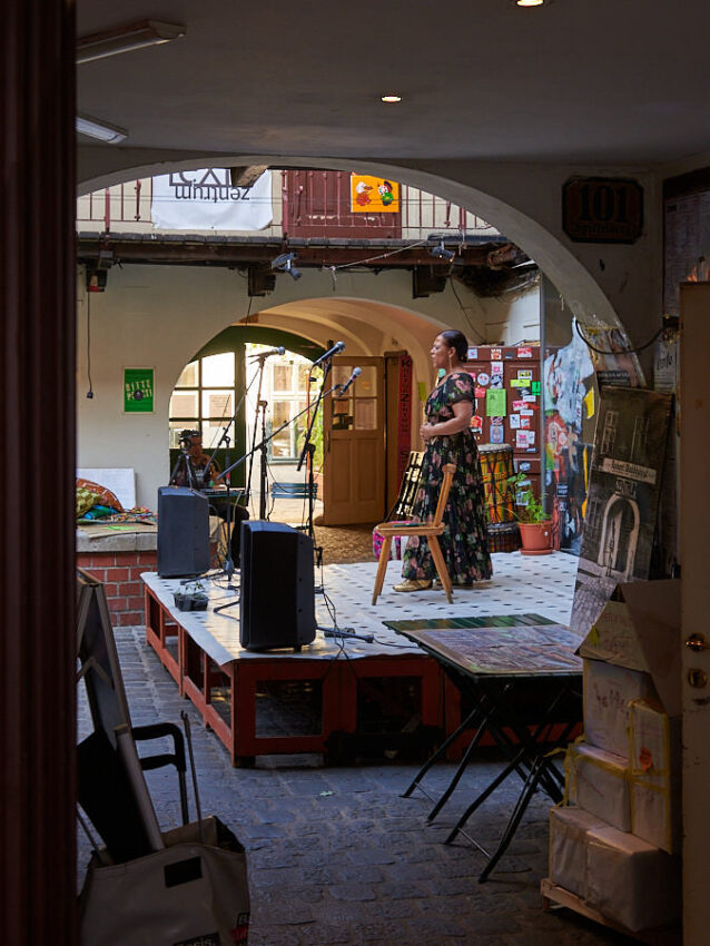 Eine Sängerin auf einer Bühne in einem Innenhof
