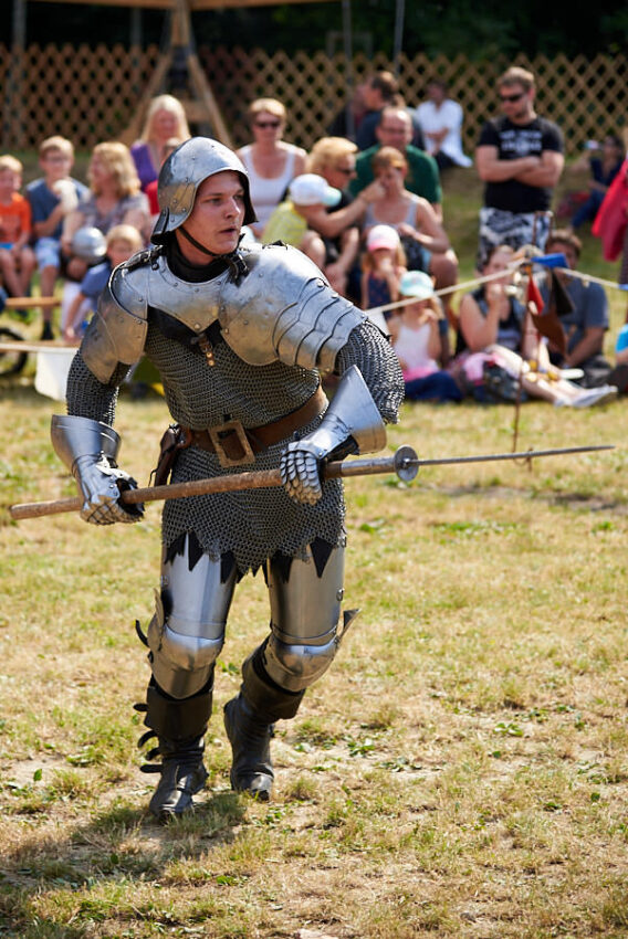 Mann in Rüstung mit offenem Helm und Stoßlanze