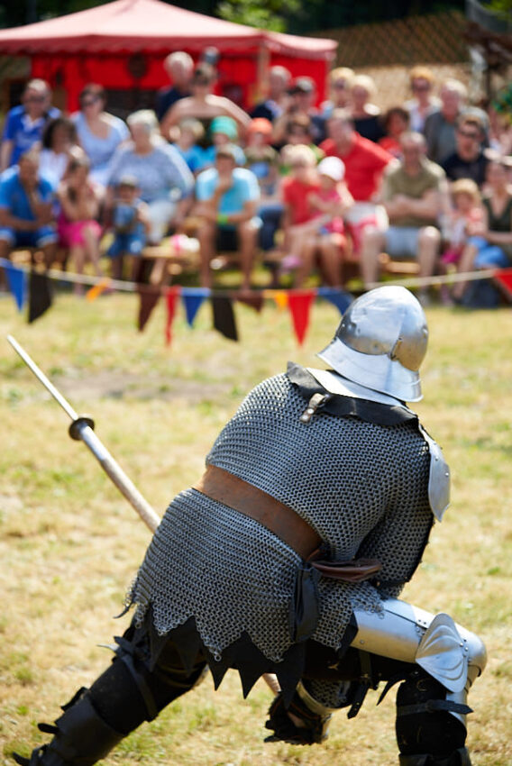 Ein Mann in Kettenhemd mit Helm und Lanze in Abwehrstellung