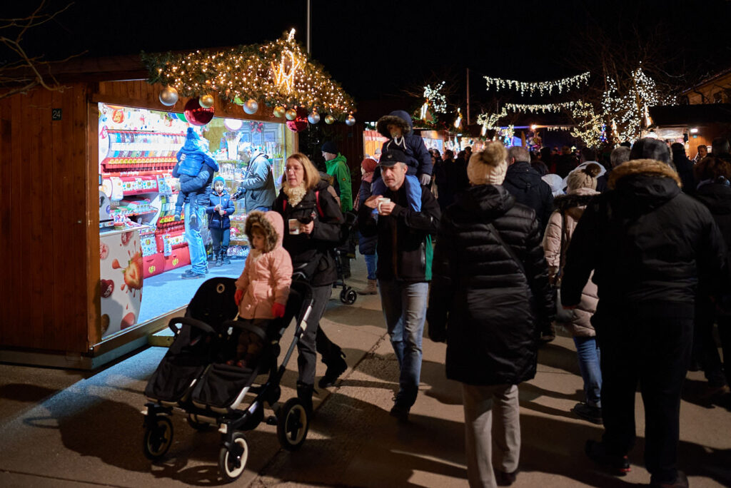Viele Menschen vor einem Marktstand mit Weihnachtsschmuck
