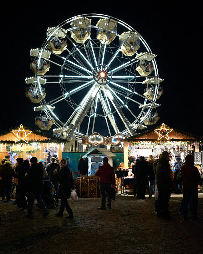 Eine Menschengruppe vor einem erleuchteten Riesenrad