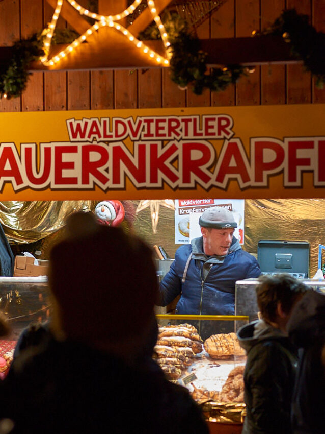 Ein Mann hinter der Budel verkauft Süßigkeiten.
