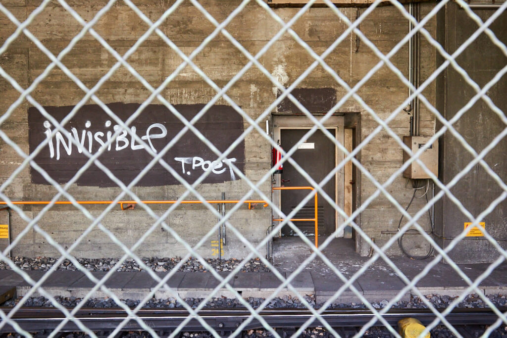 Gitter im Vordergrund, im Hintergrund die Aufschrift "Invisible"