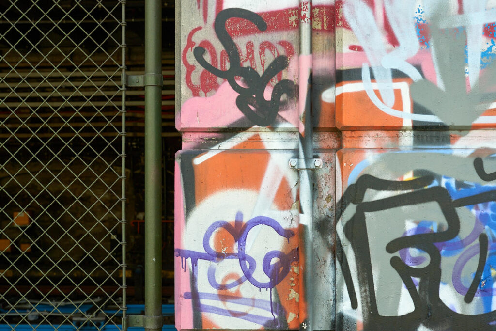 Ein Gitter neben einer Wand mit Graffiti