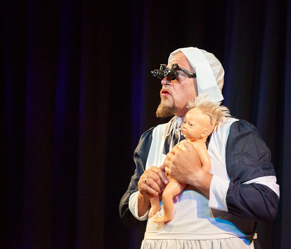 Ein Schauspieler mit Puppe in Händen