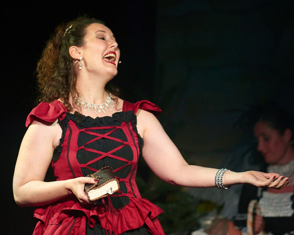 Eine Sängerin in rotem Kleid mit Buch in der Hand