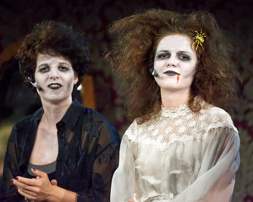 Zwei Schauspielerinnen mit weiß geschminkten Gesichtern