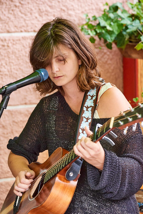 Eine Musikerin mit Gitarre und Mikrofon