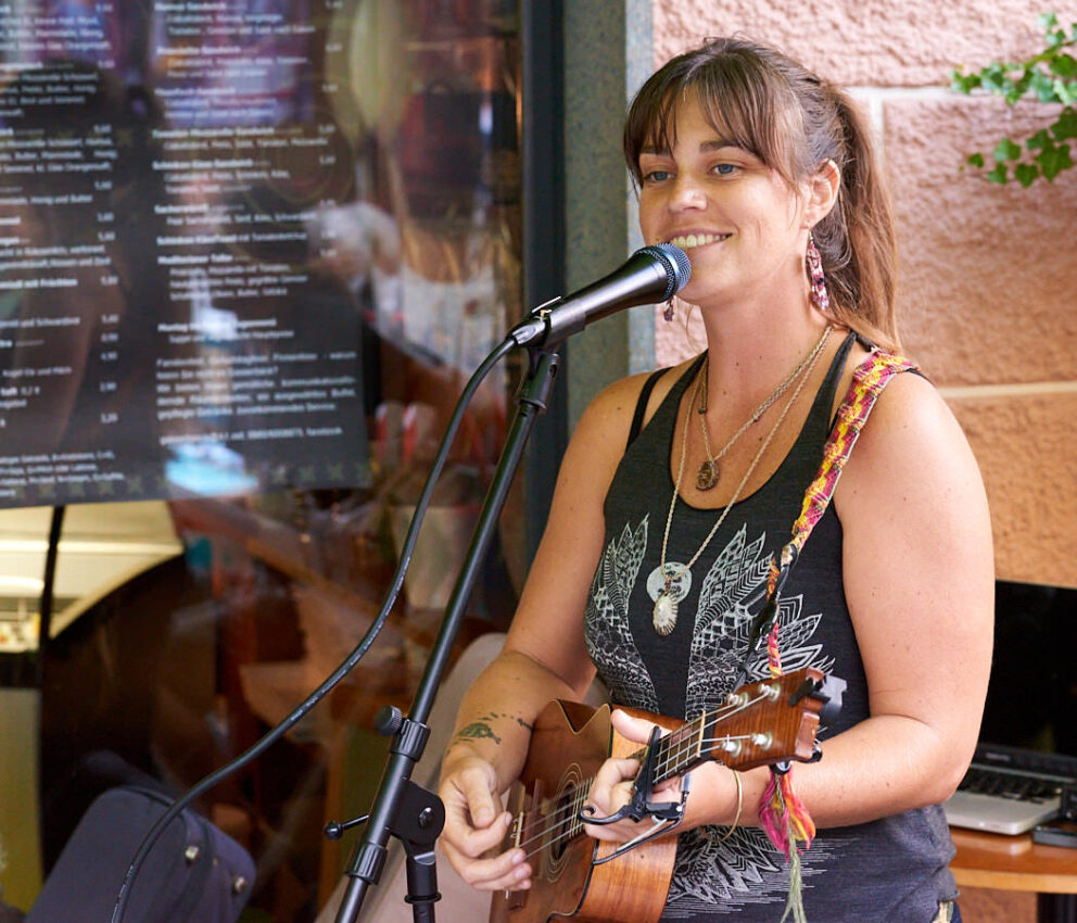 Eine Musikerin mit Gitarre und Mikrofon