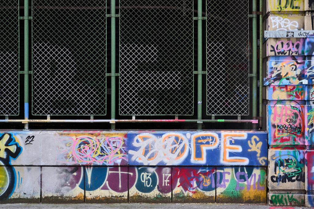 Vergitterte U-Bahntrasse mit Graffiti rundum