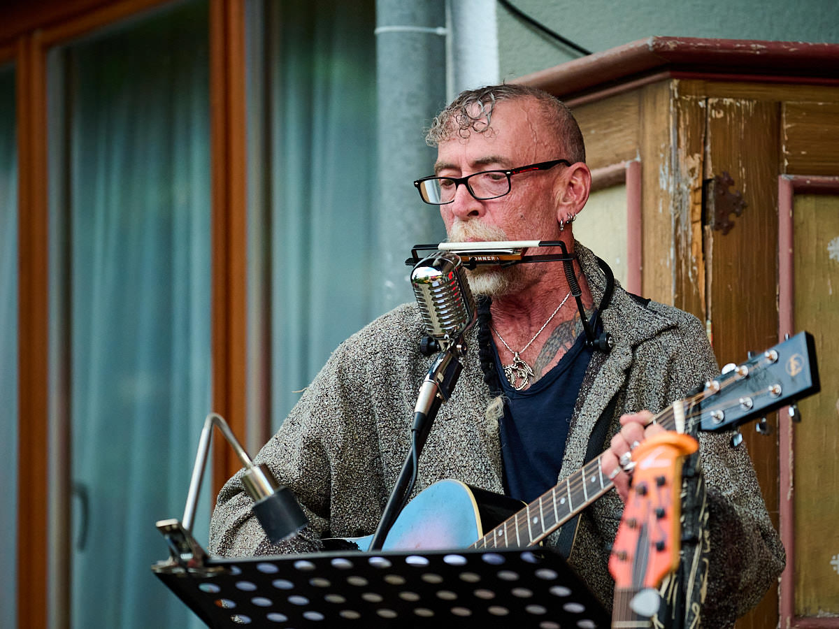 Barney Patterson vom Norbert Eipeltauer Trio spielt Gitarre und Mundharmonika.
