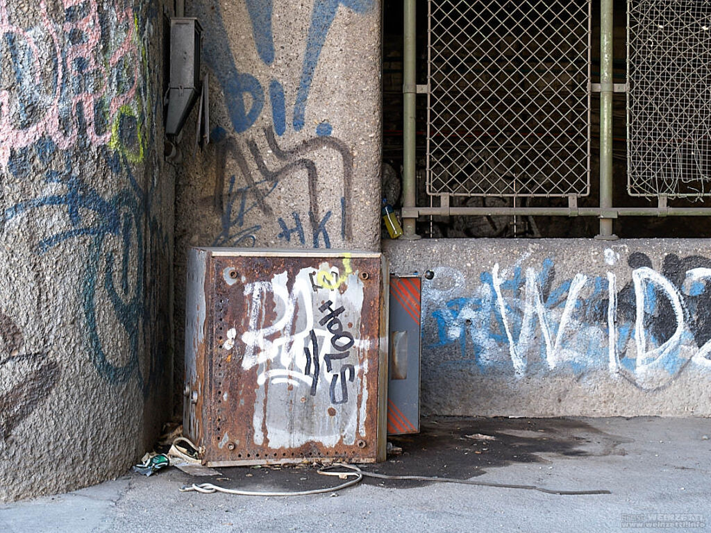 Eine Metallbox vor einer Betonwand mit Graffiti